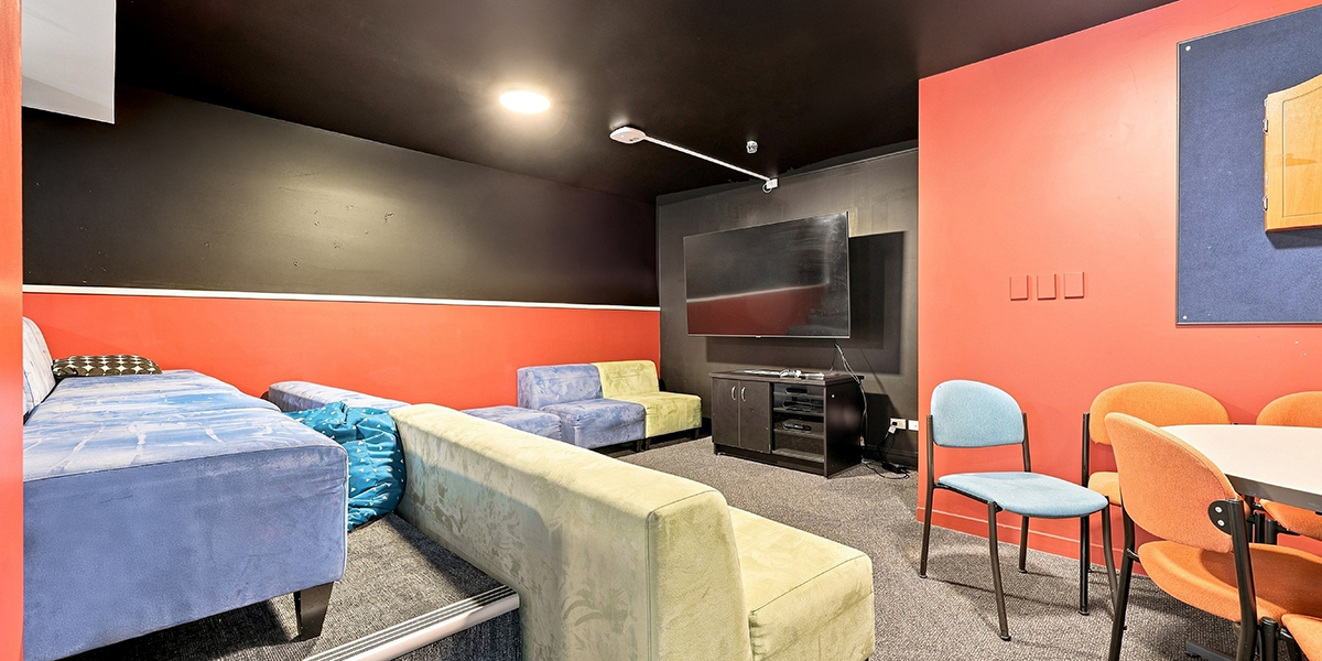 Dark movie room with seating and a TV