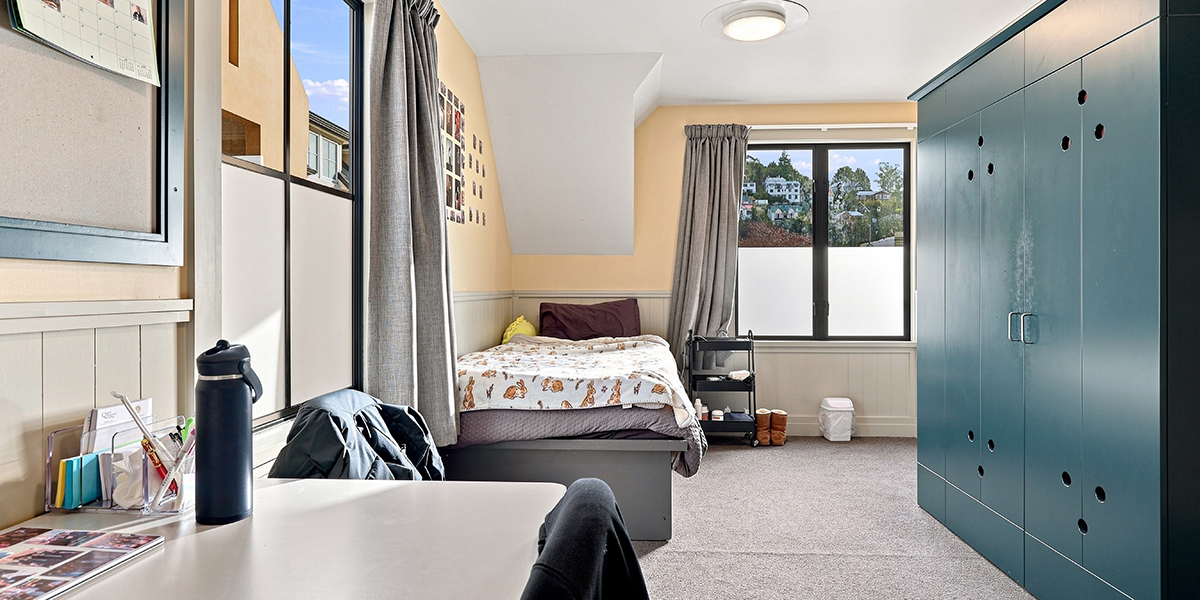 Desk, bed and wardrobe in student bedroom