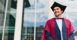 graduand in red gown and black cap image