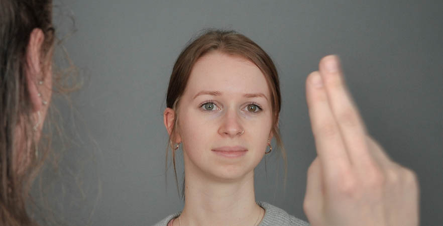 Woman looking at therapist's fingers during EMDR