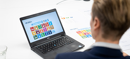 Person sitting with back to camera looking at laptop image