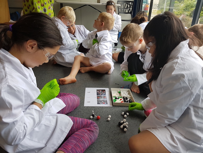 Children from Koraunui School building molecule models in the Lab in a Box.