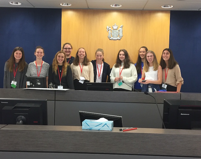Ten students stand behind the Judge's bench