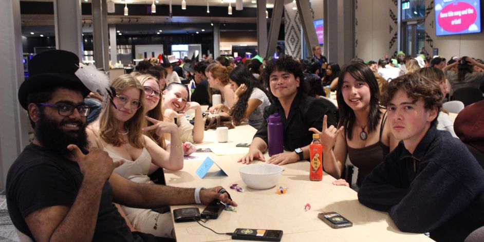 A group of students posing at their table during a quiz.