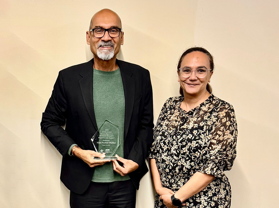 Vijay Mallan holding award trophy with Diane Ruwhiu
