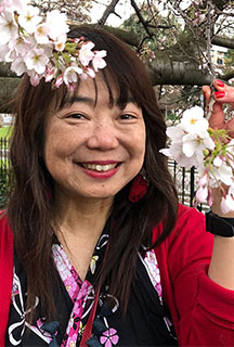 head and shoulders of a women holding blossom