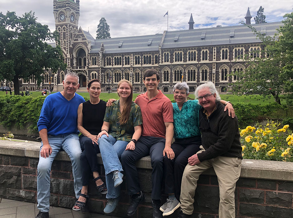 six people sitting next to each other in front of the clocktower
