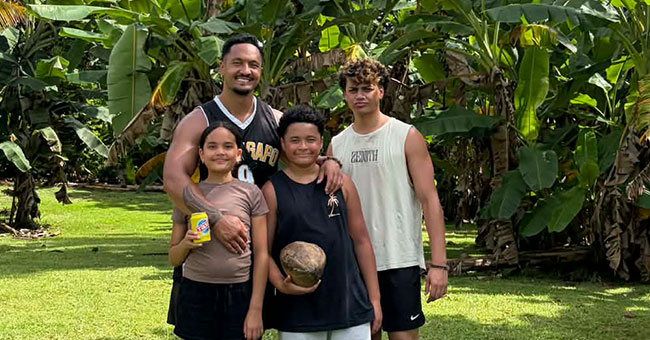 Man standing with his children - two sons and a daughter.