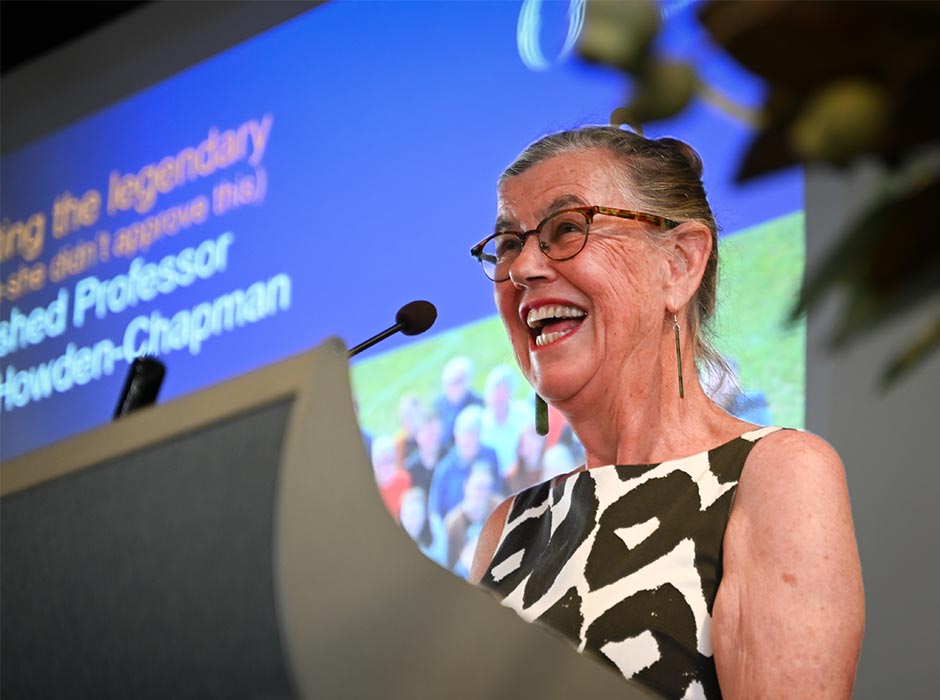 Philippa Howden-Chapman smiling behind a podium.