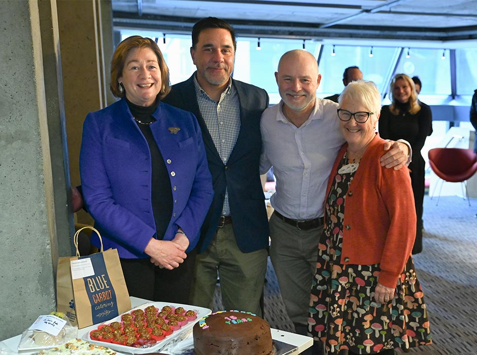 Four people pose for a photo at an event.