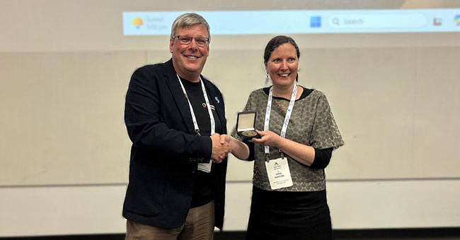 Genetics Society of AustralAsia President Associate Professor Anna Santure presents Professor Peter Dearden with the prestigious MJD White Medal for outstanding contributions to genetics research.