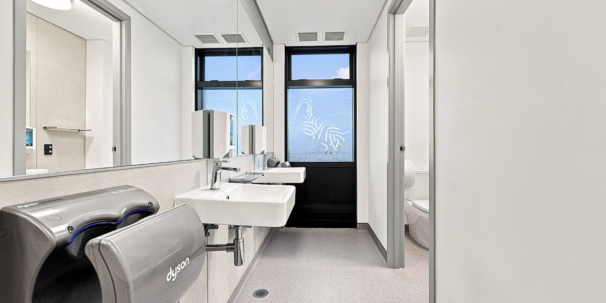 Bathroom facilities with toilet cubicles, sinks and hand dryer.
