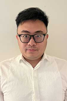 head and shoulders of a man in a white shirt and glasses