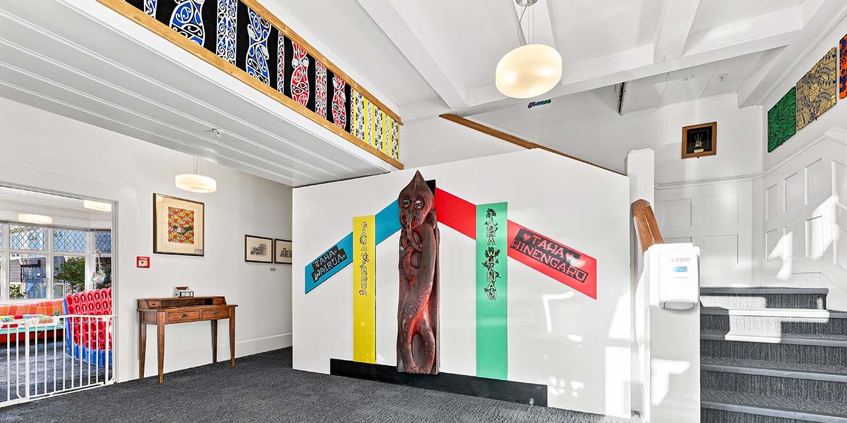 A wall display showing Te Whare Tapa Wha: Taha Wairua, Taha Tinana, Taha Whānau, Taha Hinengaro