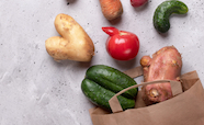 Odd shaped veges spilling from a paper bag thumb