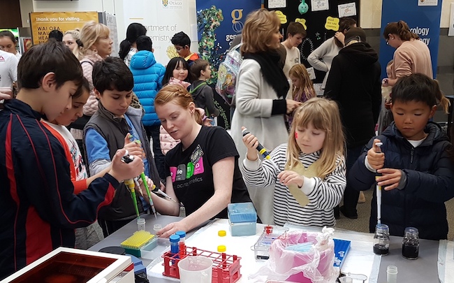 Emma Wade and 5 kids hold pipettes at the University of Otago Science Expo 2018.