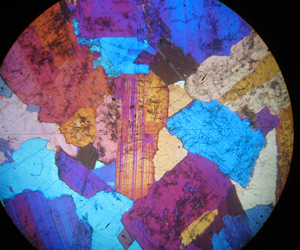Thin section of Westland Granite with crossed polars and sensitive tint plate inserted. Field of view is 5mm. 