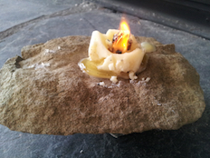 Tallow candle burning in stone lamp image by Leslie Van Gelder
