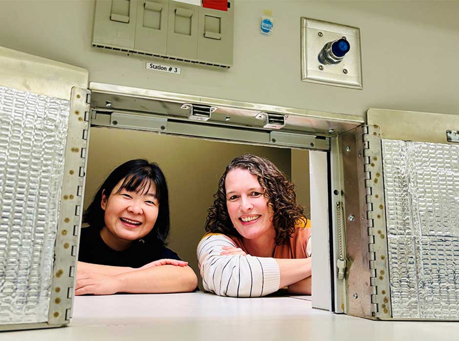 Two women between food science equpiment
