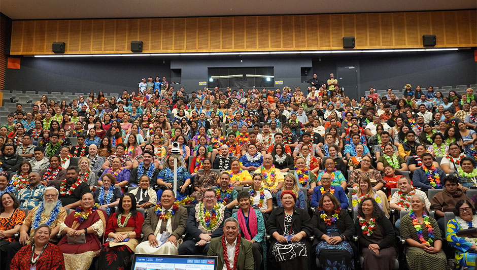 A large crowd of people sitting in an auditorium 