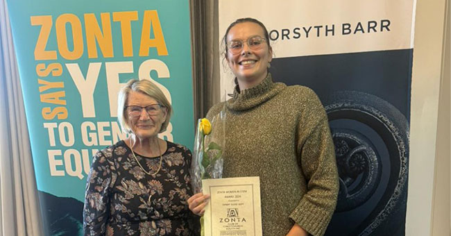 Two women pose with a certificate.