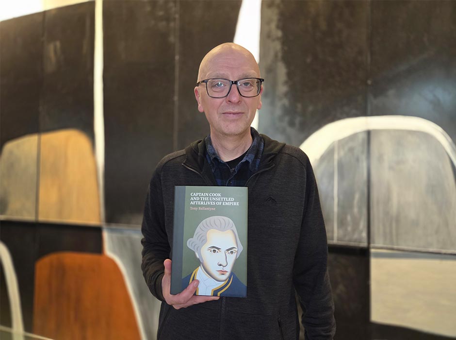 Professor Tony Ballantyne holding his new book.