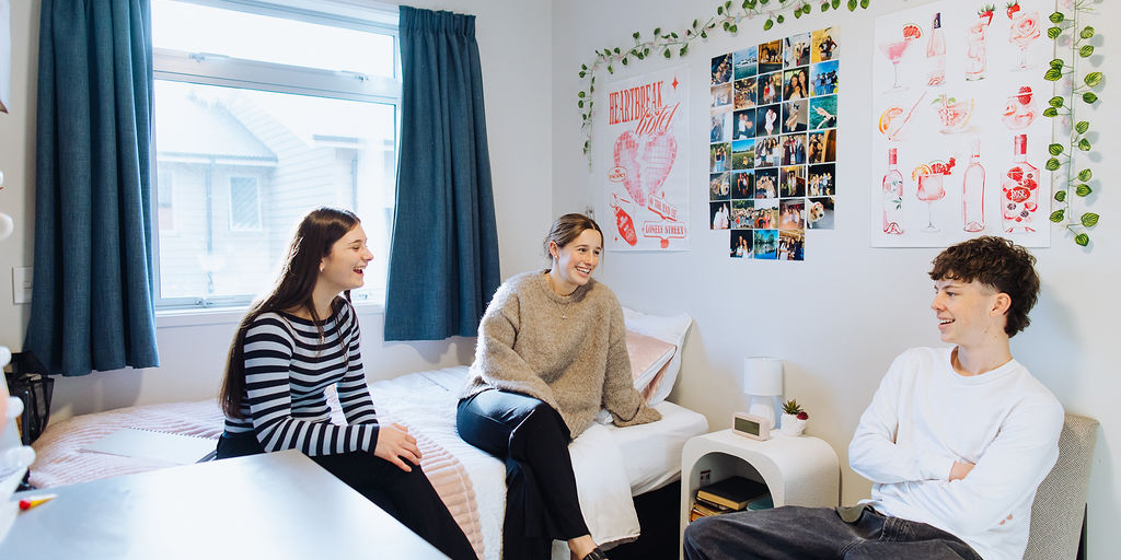 Students sitting in bedroom chatting and laughing