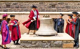 Student ringing the PhD submission bell on campus