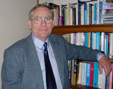 Alan MacGregor standing in front of a bookcase