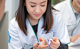 Pharmacy student obtaining a blood sample from her finger-thumbnail