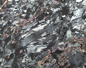 Footwall fault schist microscope view. Ribbons of quartz run through with grains that are typically .1mm wide.