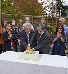 Group of people outside cutting cake