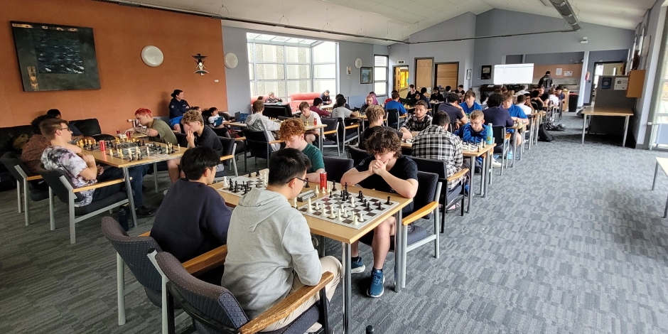 Room full of people playing many games of chess.