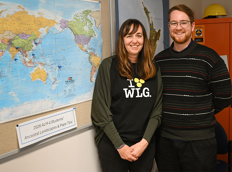 A young woman and man standing next to a map 