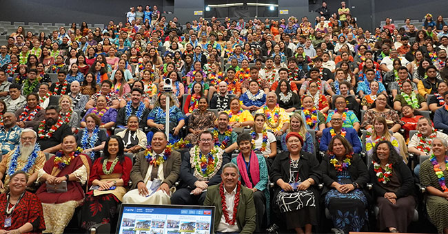 A large crowd of people sitting in an auditorium 