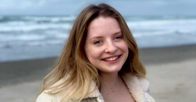 A picture of a young woman with the sea in the background.