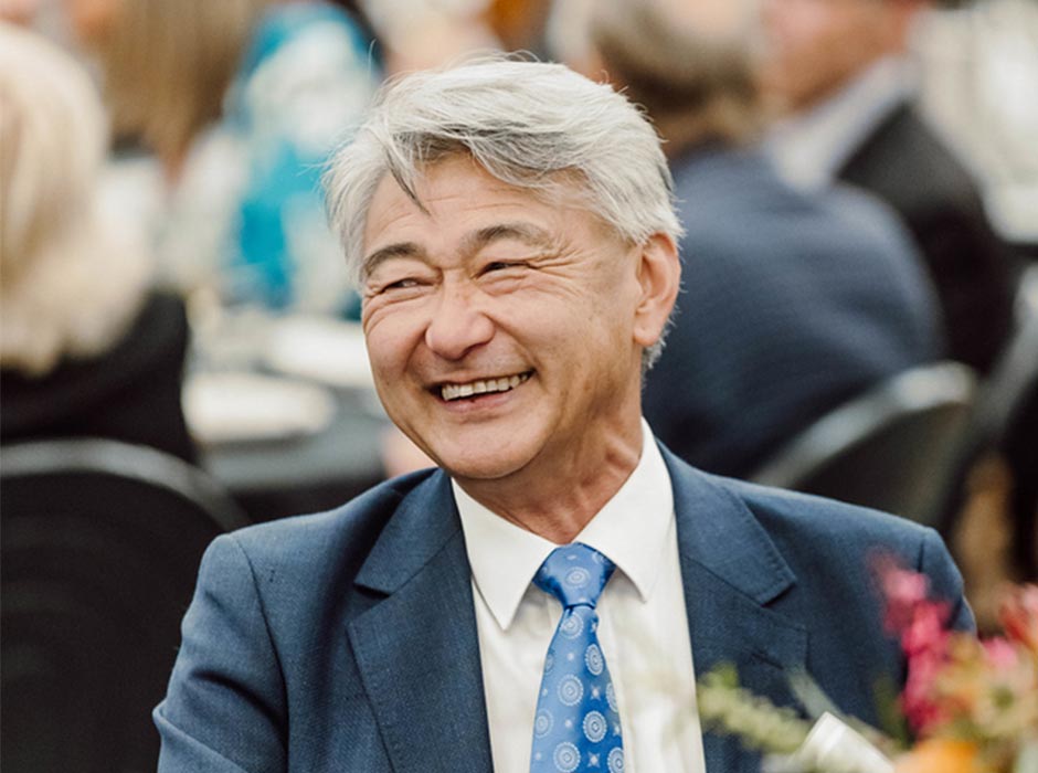A smiling man is pictured seated at an event.