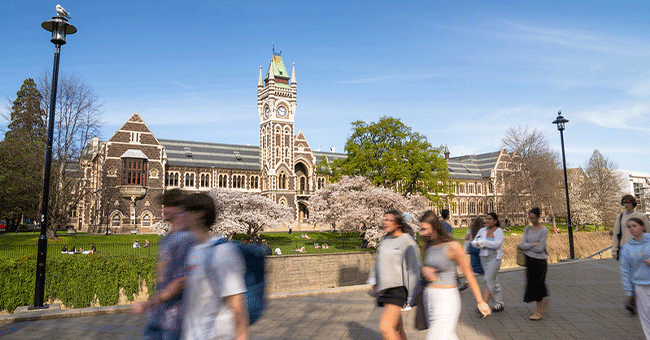 otago campus with clocktower in background and blurred students in foreground
