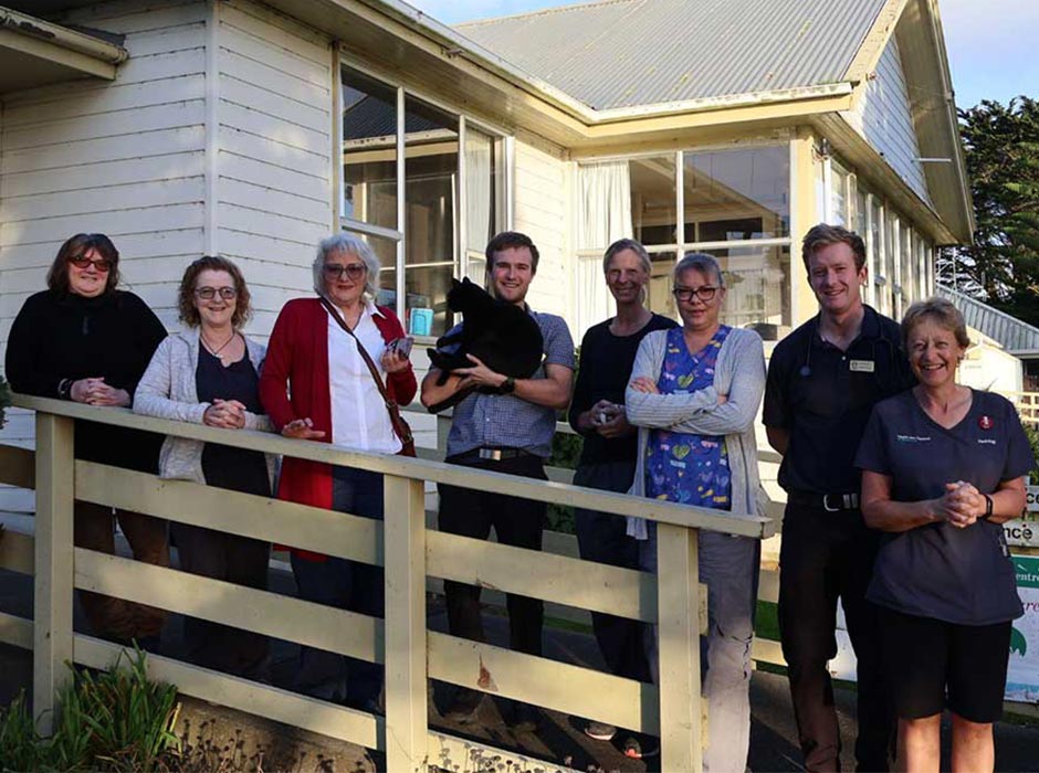 A group shot of people, with one holding a cat