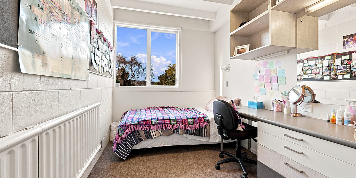 Student bedroom with desk and shelving