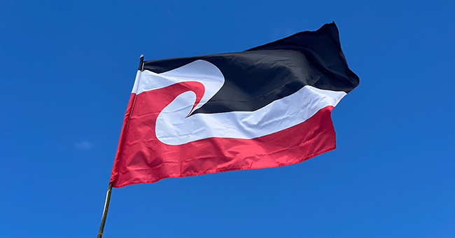 Māori flag in front of clear blue sky background
