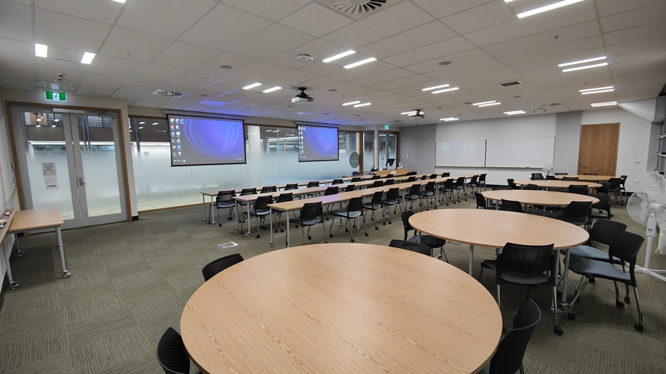 View of Otago Business School room 119, showing tables and chairs in rows and groups