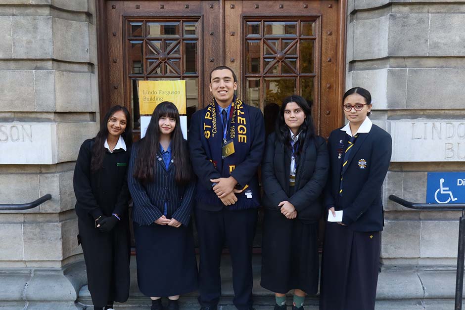 A small group of Pacific Island students in school uniforms standing outside the University of Otago's Lindo Ferguson building