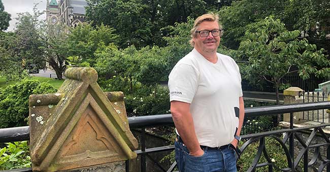 A standing in front of a hand rail on a bridge