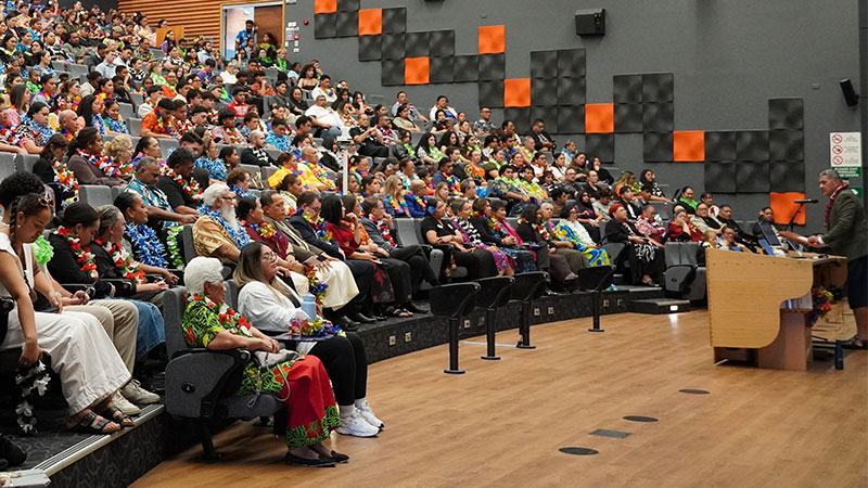 A man addressing a crowd from a lecturn