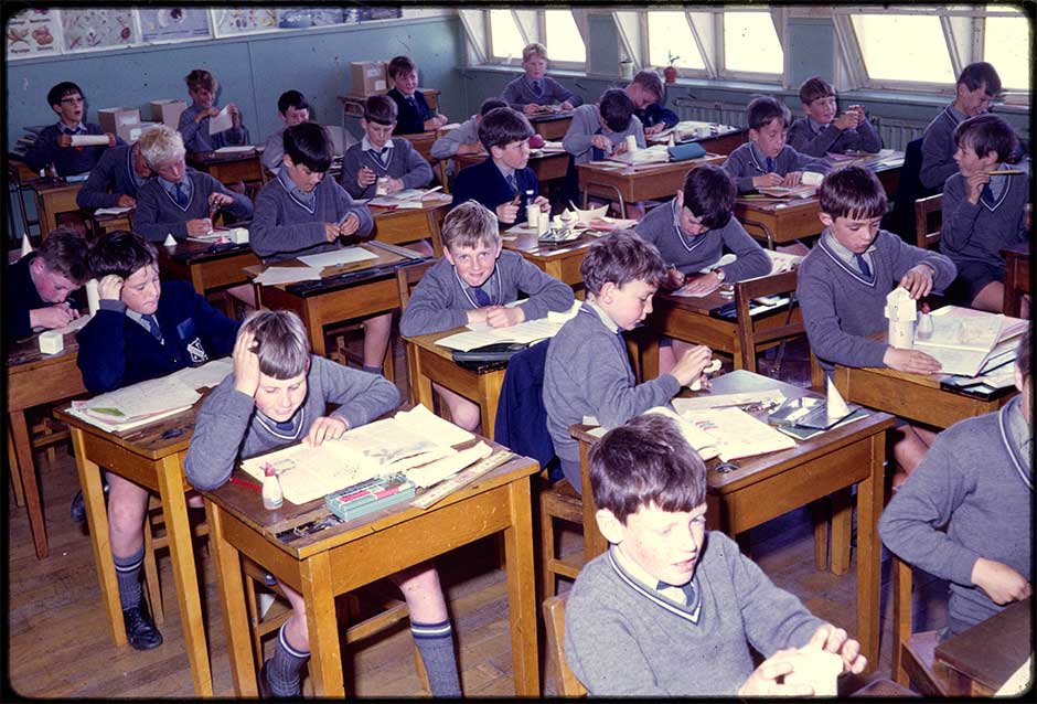 A classroom of boys in uniform seated at desks