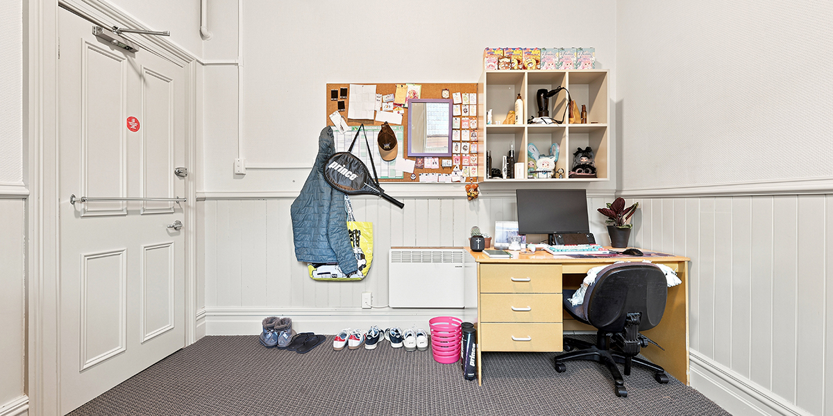 Desk with chair and book shelves in student bedroom