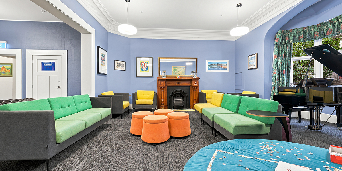 Common lounge area with sofas, piano and fireplace