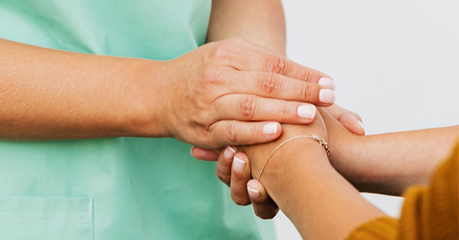 Women holding hands in scrubs thumbnail