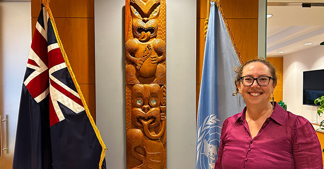 Louise-Parr-Brownlie standing in front of the NZ and UN flags